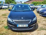 une voiture noire garée sur un parking, avec d'autres voitures en arrière-plan