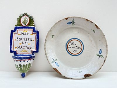 une assiette et un bol sur une étagère, l'un à côté de l'autre