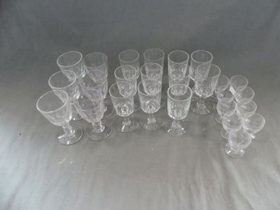 douze verres transparents alignés en rang sur une table
