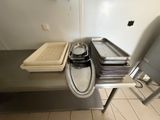 Plusieurs plateaux de nourriture sont posés sur une table en métal dans une cuisine