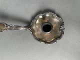 a silver spoon that has a black hole in it