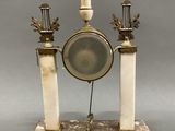 a clock that is sitting on a marble stand