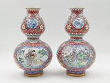 pair of chinese vases with painted figures on them on a white background