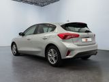 the rear end of a silver car in a white room
