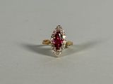 a close up of a red and white diamond ring on a white surface