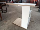 une table blanche sur laquelle se trouve une étagère, dans une pièce