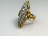 gros plan d'une bague en or avec des diamants sur une surface blanche