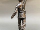 bronze statue of a man with his arm raised in the air