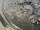 a silver plate with a picture of a woman on it