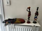 two figurines sitting on a shelf next to a radiator