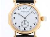 une montre-bracelet en or avec un cadran blanc et un bracelet noir