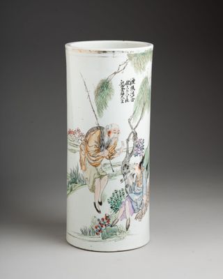un vase blanc avec un tableau sur une table