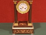 une horloge posée sur une table à côté d'une clé