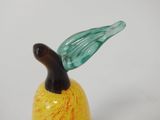 a glass figurine of a yellow pear with a green leaf on top