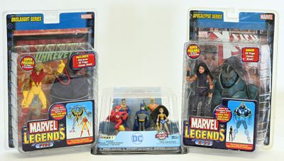 three action figures of different characters in plastic packaging on a white surface