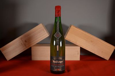 a bottle of wine sitting on a table next to a wooden box