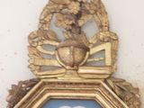 a clock on the wall with a gold frame on it