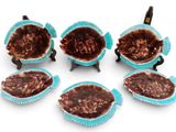 six caissettes à cupcakes bleues alignées sur une surface blanche