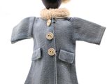 un mannequin vêtu d'un manteau et d'un chapeau