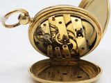 an image of a gold pocket watch on a white surface