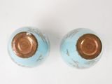two blue and gold vases sitting on a white surface