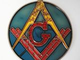 a picture of a stained glass medallion with a masonic symbol on it