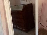 a large mirror in the corner of a room next to a bed