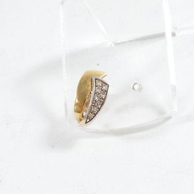 une paire de boucles d'oreilles en diamant dans une boîte transparente posée sur un fond blanc