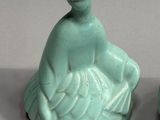 two ceramic figurines that are sitting on a table