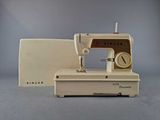 a white sewing machine sitting on a table next to a box