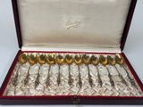 six silver spoons in a red box on a white surface