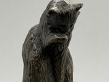 une statue représentant un chat assis sur une table