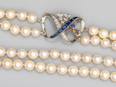 un gros plan sur un collier orné de perles et d'une broche