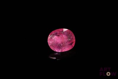 a close up of a pink diamond on a black surface