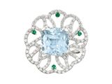 un gros plan d'une bague sertie d'une topaze bleue et d'émeraudes