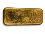 gros plan d'un lingot d'or sur une surface blanche