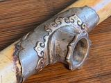 a wooden stick with a metal handle on a wooden table
