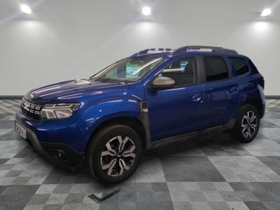 a blue dacia is parked in a room with checkered floor