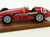une maquette rouge d'une voiture de course posée sur un socle en bois
