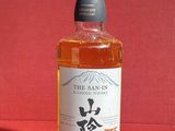 une photo d'une bouteille de whisky posée sur une table rouge