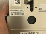 a hand that is holding an electronic device with a sticker on it