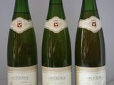 trois bouteilles de vin posées sur une table, l'une à côté de l'autre