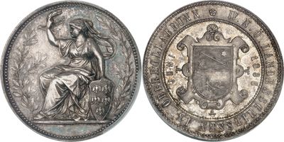 a silver coin with a woman sitting on top of it