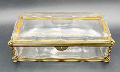 a clear glass box sitting on top of a table next to a black table