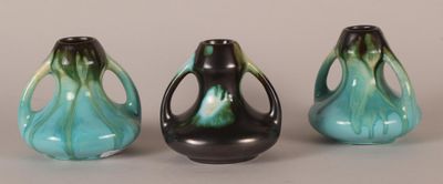 three black and green vases sitting next to each other on a table