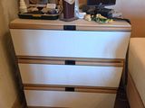 a white dresser with drawers in a small room