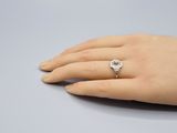une image représentant la main d'une femme portant une bague en diamant