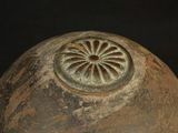 a large brown vase with a circular design on it