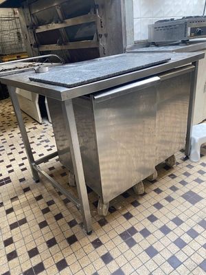 une cuisine équipée d'appareils électroménagers en inox et d'un sol carrelé