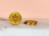 a gold coin sitting next to a gold coin on a marble surface